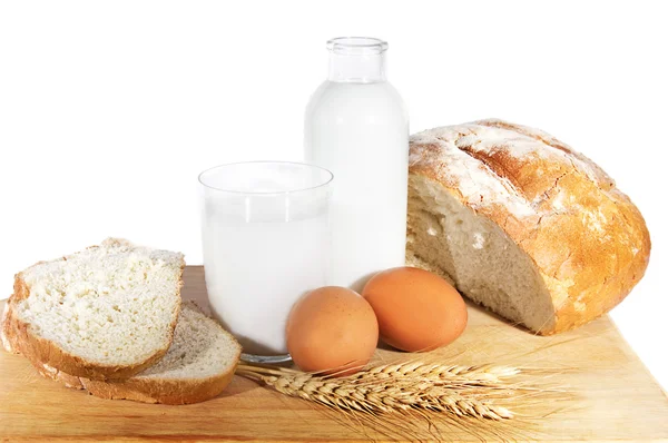 Milk, eggs, bread and wheat corn on white