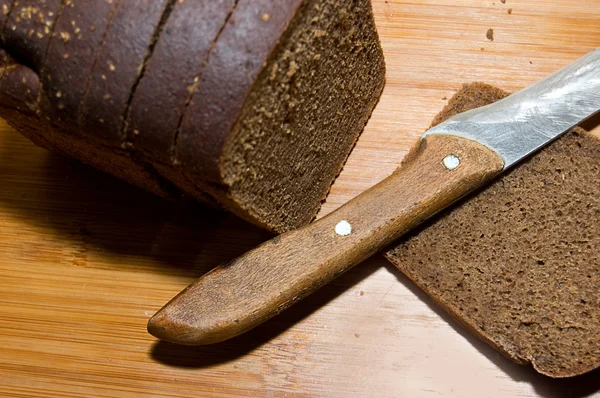 Bochenek chleb czarny i nóż — Zdjęcie stockowe