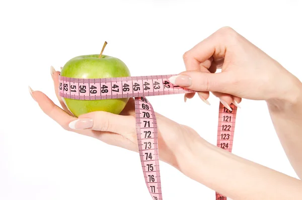 Mani donna misurazione mela verde — Foto Stock