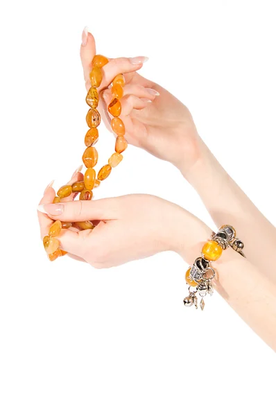 Händer som håller bärnsten halsband och armband — Stockfoto