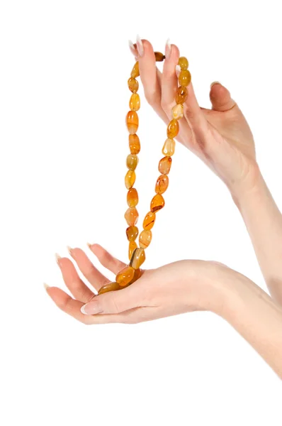 Руки женщины держат янтарное ожерелье — стоковое фото