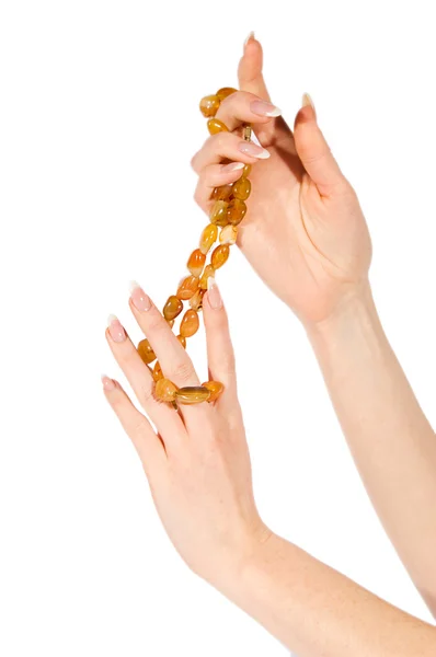 Руки женщины держат янтарное ожерелье — стоковое фото