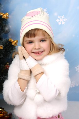 Beautiful girl in a fur cape, hat and gloves around the Christma clipart