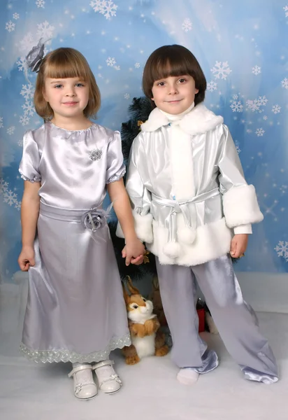 Roztomilý dívka a chlapec oblečená v šatech na modrém pozadí — Stock fotografie