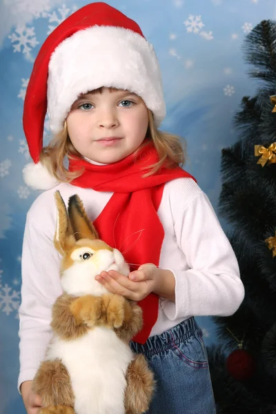 Portrait of a beautiful girl in a Santa Claus hat with a rabbit — Stock Photo, Image