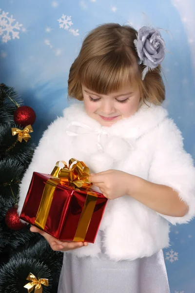 Πορτρέτο του ένα όμορφο κορίτσι σε ένα άσπρο παλτό με ένα δώρο — Φωτογραφία Αρχείου