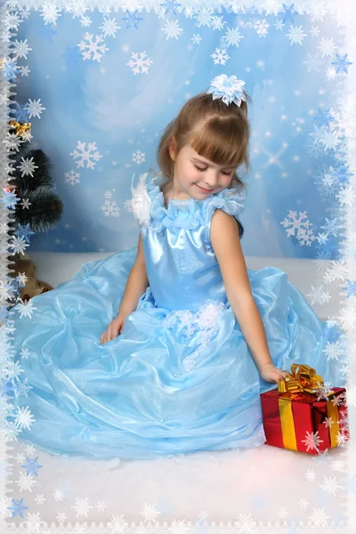 Noel ağacının etrafında şık mavi elbiseli güzel kız oturdu — Stok fotoğraf