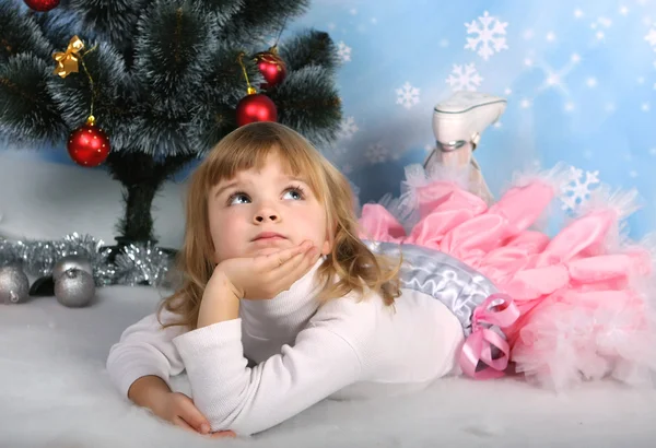 Hermosa chica con un regalo se encuentra cerca del árbol de Navidad — Foto de Stock