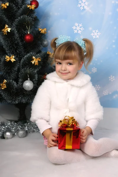 Belle fille dans un manteau de fourrure autour du sapin de Noël avec gif — Photo