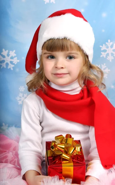 Retrato de uma menina bonita em um chapéu de Papai Noel com um presente — Fotografia de Stock