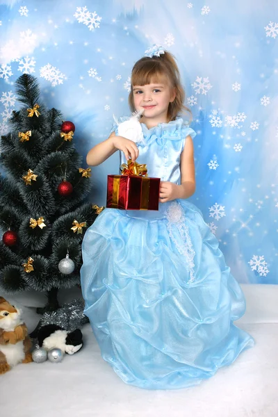 Krásná dívka v nóbl modrých šatech kolem vánočního stromku s — Stock fotografie
