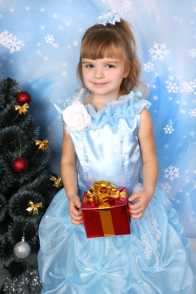 Krásná dívka v nóbl modrých šatech kolem vánočního stromku s — Stock fotografie