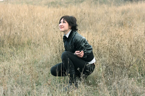 Dívka v oblasti suché trávy, podíval se na oblohu a úsměvy — Stock fotografie