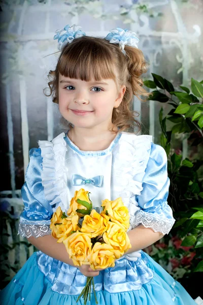 Menina bonita em um vestido azul de pé com um buquê de amarelo — Fotografia de Stock