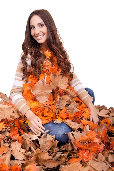 Счастливая женщина, покрытая осенними листьями — стоковое фото