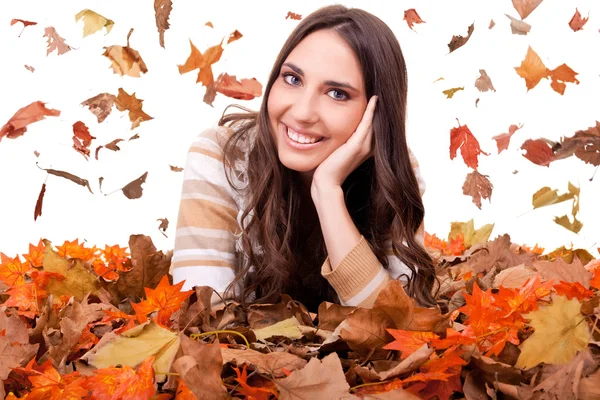 Mujer de otoño en un montón de hojas de colores — Foto de Stock