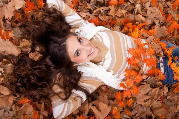 Bella donna sdraiata sulle foglie d'autunno — Foto Stock