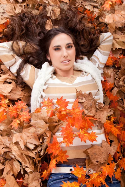 Mujer morena bonita en hojas de otoño —  Fotos de Stock