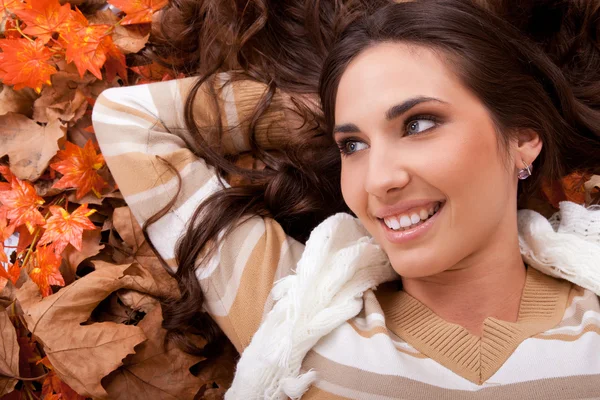 秋の葉の上に横たわる幸せな女の子 — ストック写真