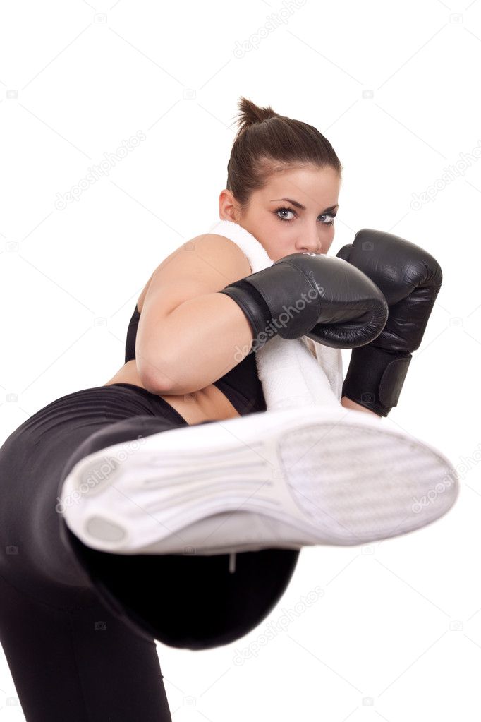Pretty girl with boxing use gloves giving a kick