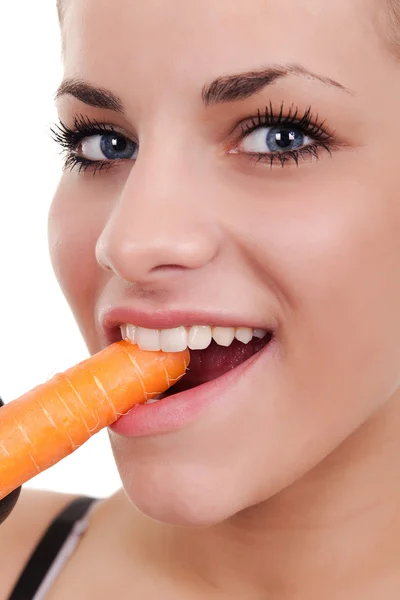 Woman biting raw carrot — Stockfoto