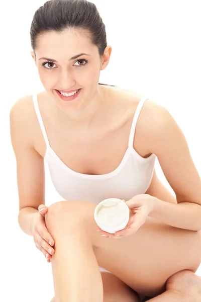 Vrouwelijke zetten vochtinbrengende crème op poten — Stockfoto