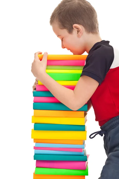 O miúdo da escola tem uma pilha de livros. — Fotografia de Stock