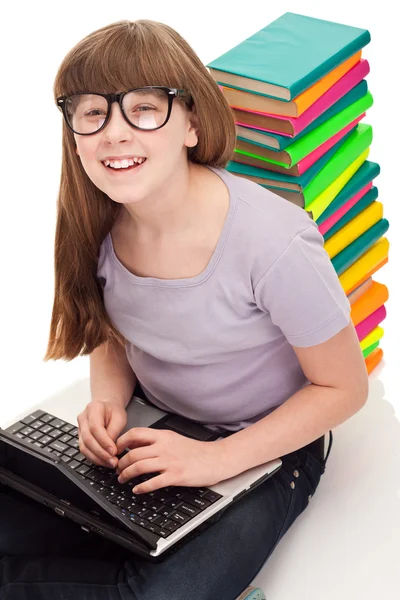 Meisje met kleurenboeken en laptop — Stockfoto