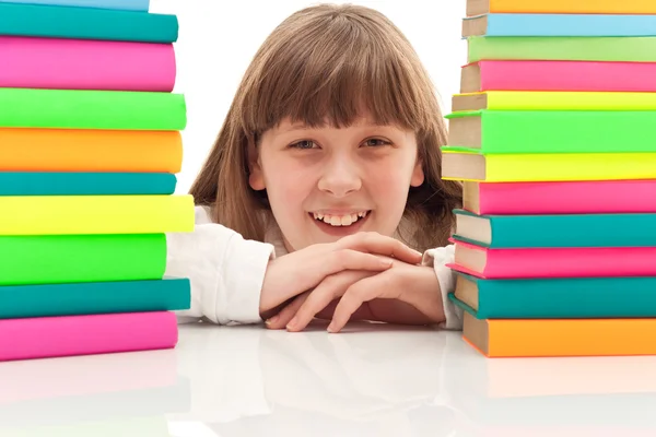 Girl between two piles of books — Stock Photo, Image