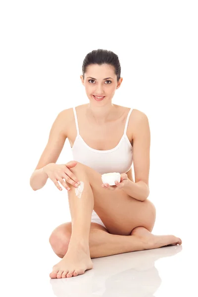 Vrouw die crème op de benen aanbrengt — Stockfoto