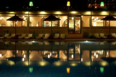 Night swimming pool side of tropical hotel clipart