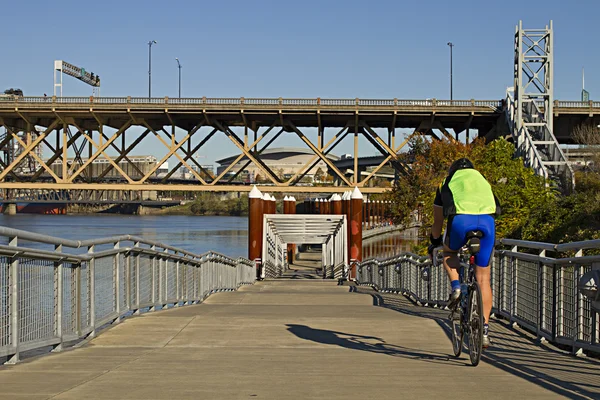 Unbekannter Radfahrer fährt mit Fahrrad am Fluss entlang — Stockfoto