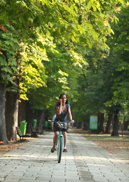 Mulher no telefone andar de bicicleta — Fotografia de Stock