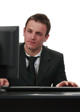 Image of a young businessman working on his computer. clipart