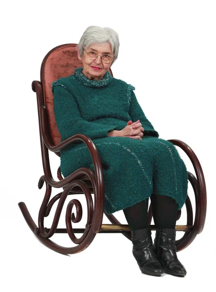 白い背景に対して隔離される木製のロッキングチェアに座っている古い女性 — ストック写真