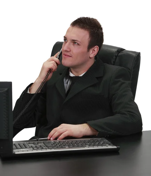 坐到他办公桌 孤立白色背景时使用电话的一位商人的形象 — 图库照片