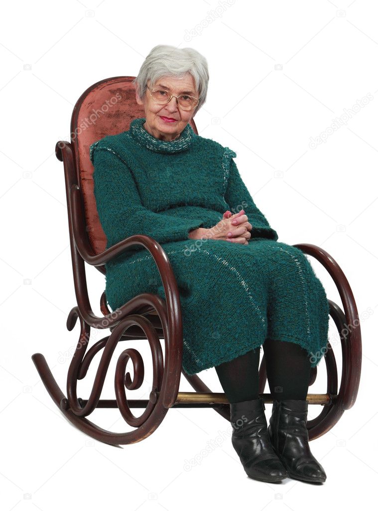 Old woman sitting on a wooden rocking chair isolated against a white background.