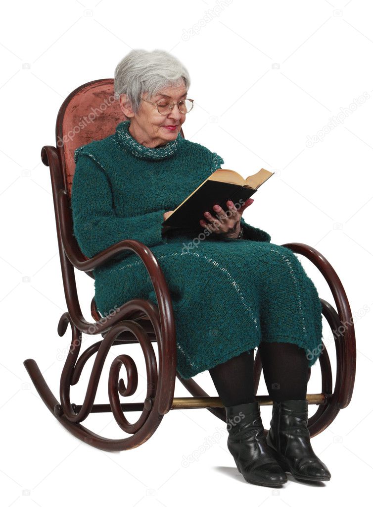 Old woman reading a black book while sitting in a rocker, isolated against a white background.