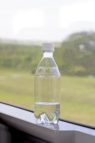 Een Fles Met Mineraalwater Deurframe Een Trein Snelle Beweging — Stockfoto