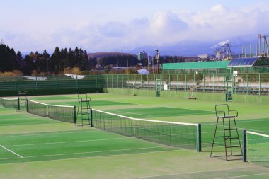 General view of few tennis courts in a sports complex at the margin of a city. clipart