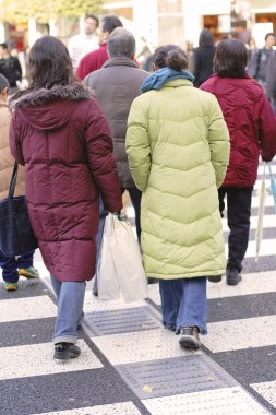 crowd crossing the street in an autumn day. clipart