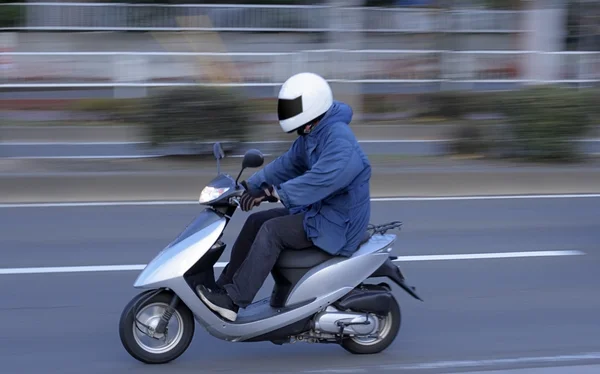 都市でスクーターに乗って男の画像をパン — ストック写真