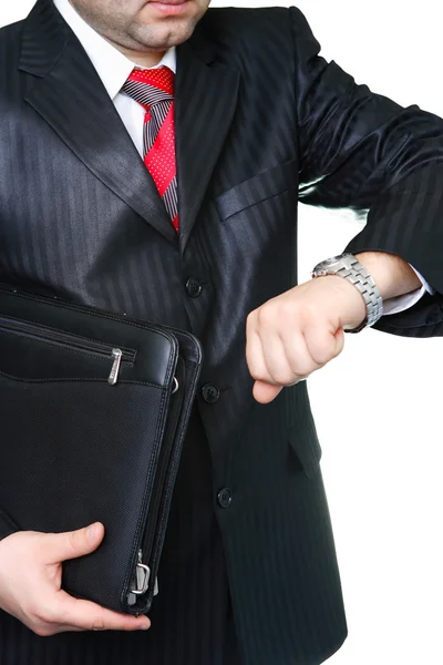 ポートフォリオを持つ黒のスーツのビジネスマン 腕時計を見る — ストック写真