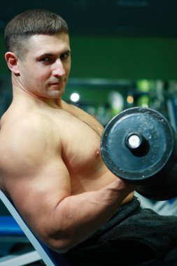 The young man with a well-muscled body poses and shows the sports body clipart