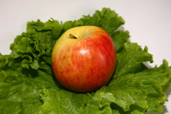 Apfel auf Salatblatt Stockbild
