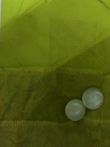 緑の布の背景に つの玉ボタン — ストック写真