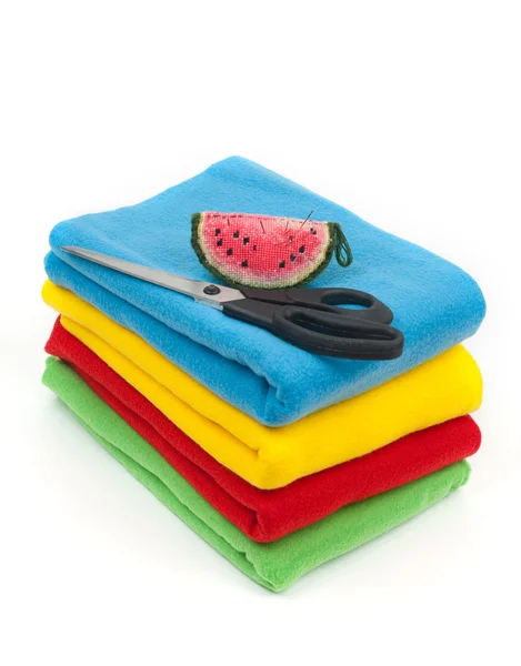 Fabric of different colors with a needle case and scissors — Stock Photo, Image