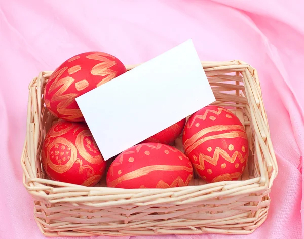 Huevos de Pascua en una cesta de paja —  Fotos de Stock