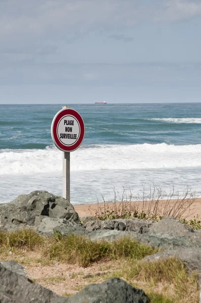 Señal de advertencia francesa en una playa —  Fotos de Stock
