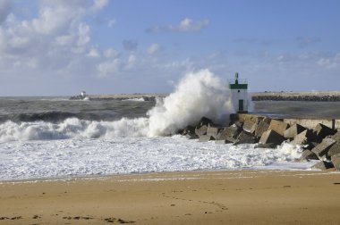 büyük bir dalga üzerinde küçük bir deniz feneri